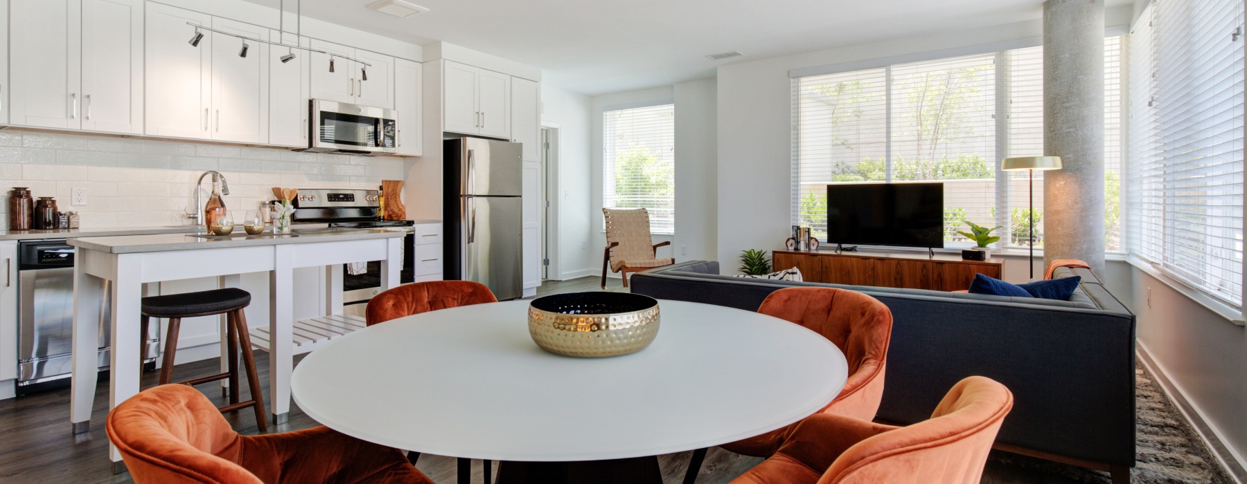 a kitchen with dining room and living room with couches