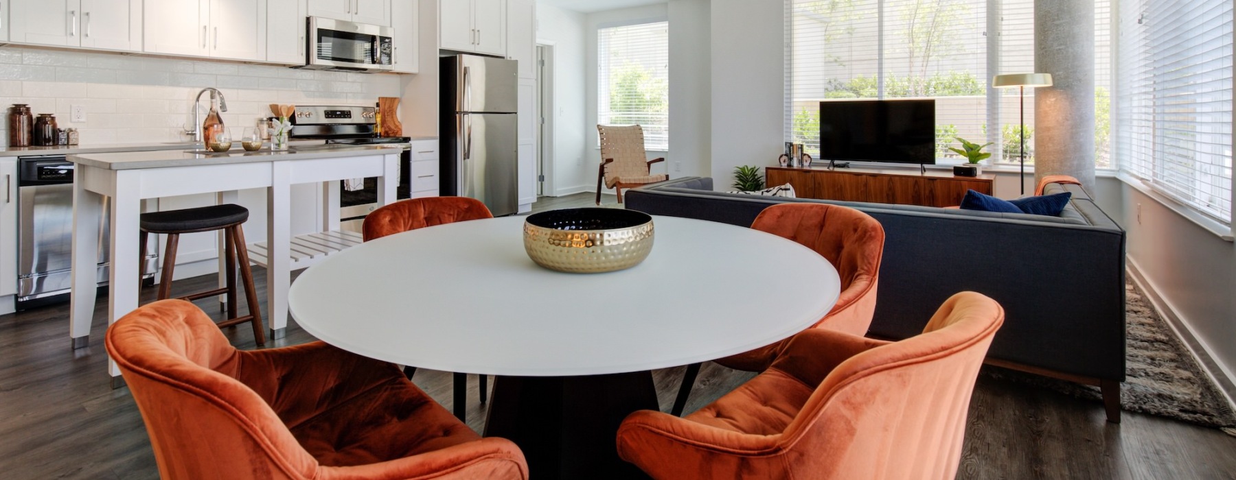 a kitchen with dining room and living room with couches