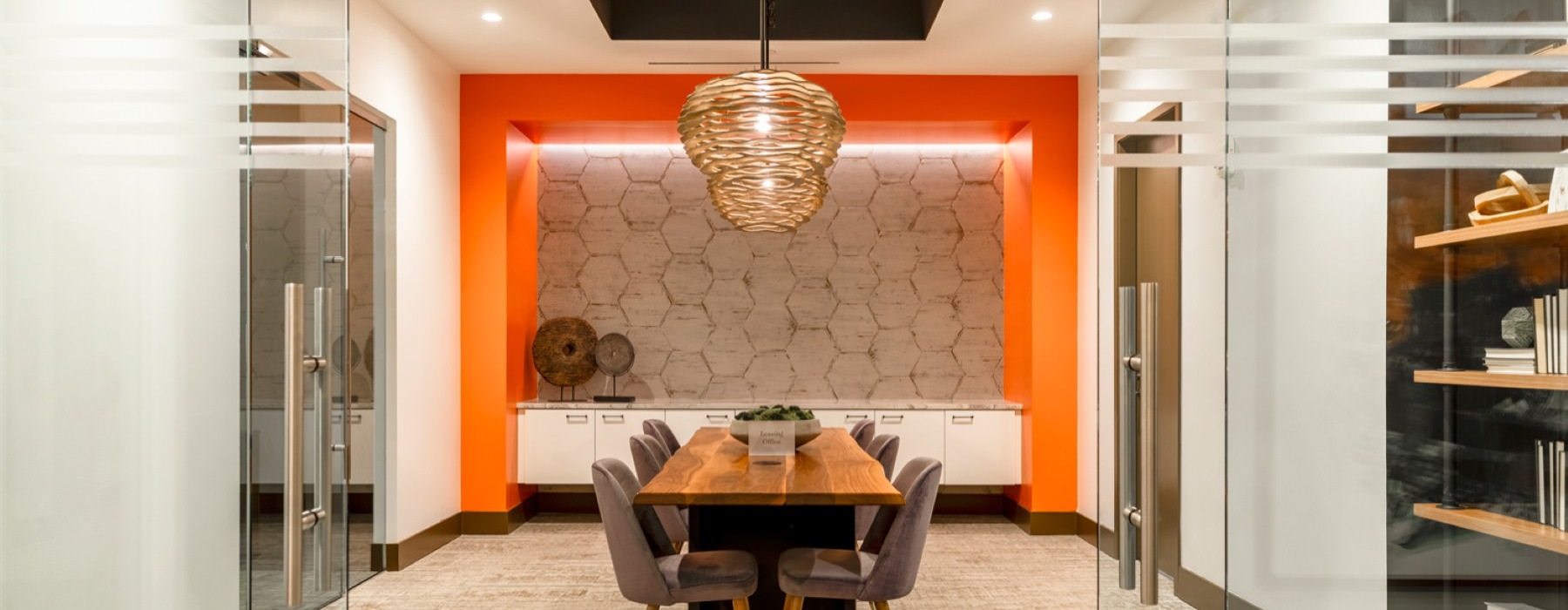 a clubhouse room with a chandelier and a table