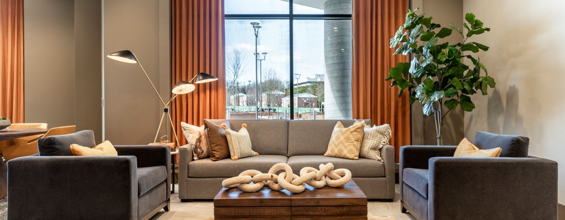 a clubhouse room with a large window, couches and a table